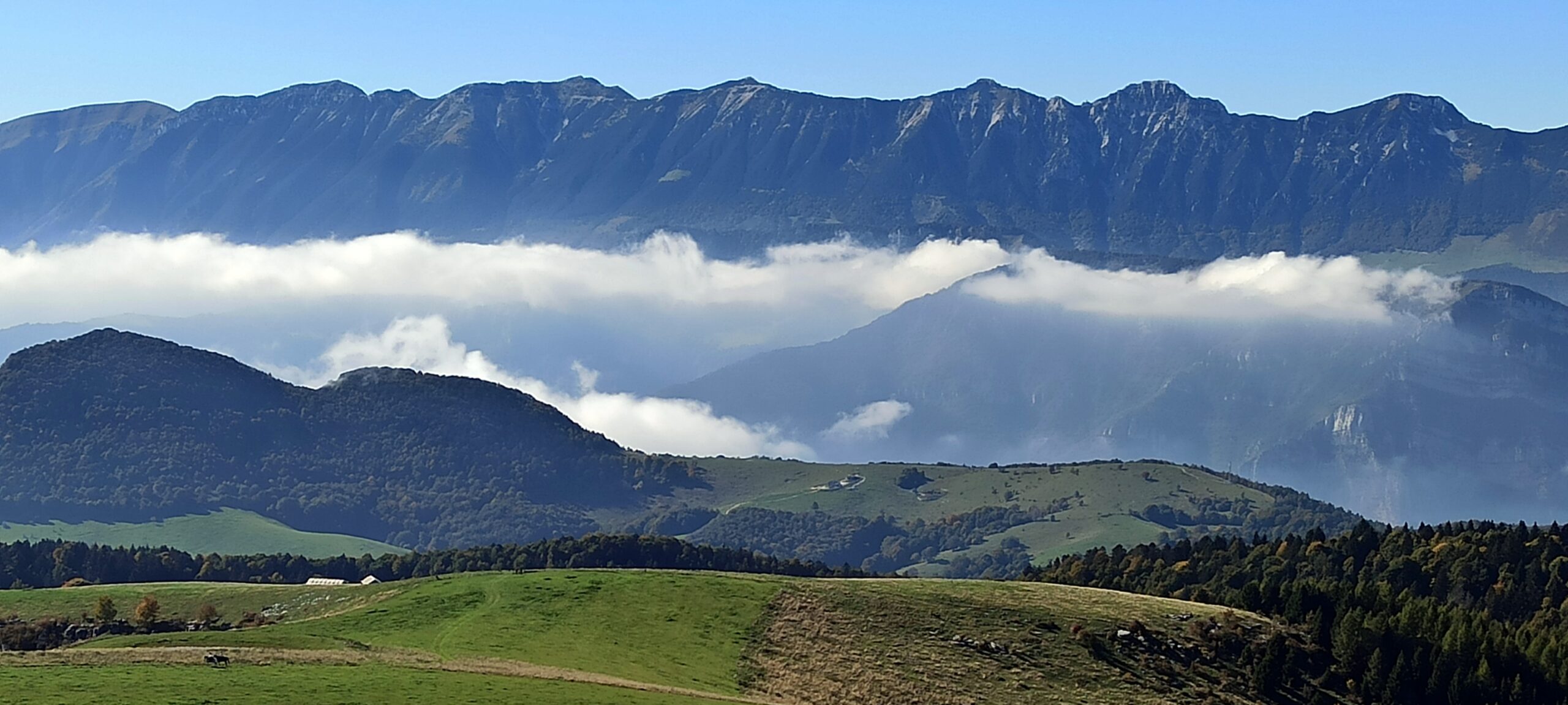 La spettacolare vista del Monte Baldo dalla Lessinia. Solo le nuvole segnalano dove corre la Val d'Adige